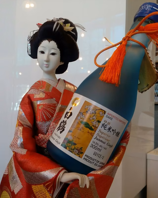 Japońska lalka w kimonie z butelką sake